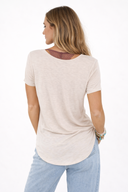 Woman wearing a beige t-shirt with a mesh back panel on a white background